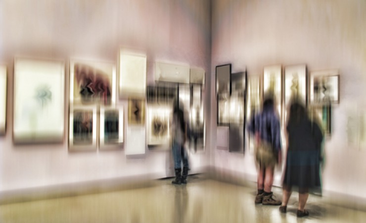 group of people examining paintings at nyc museum
