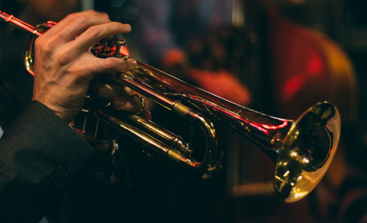 hand fingering trumpet in club lighting