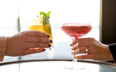 two women drinking cocktails in the sun