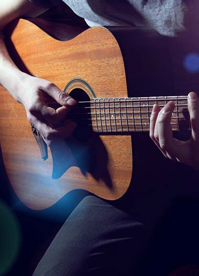 Close up of a man playing an acoustic guitar