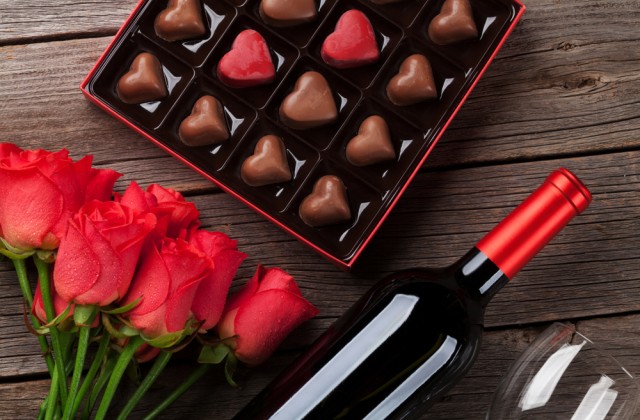 roses chocolates and a bottle of red wine