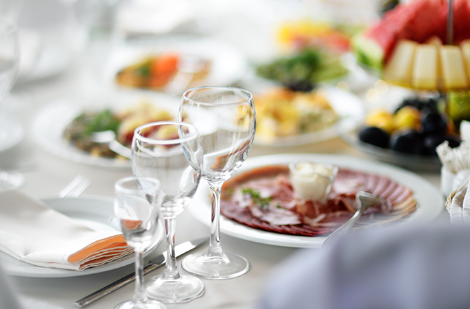 table set up for a brunch buffet with some sliced meats and fruit