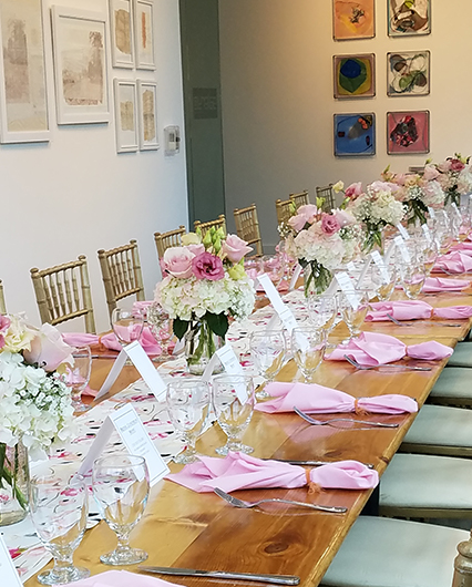 bridal event set up in the gallery with a long table and pink place settings