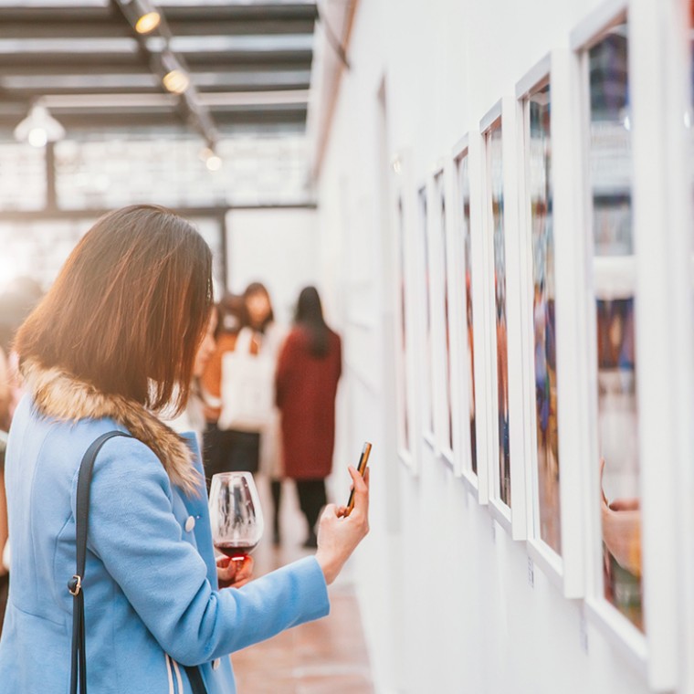Woman taking picture of art at museum