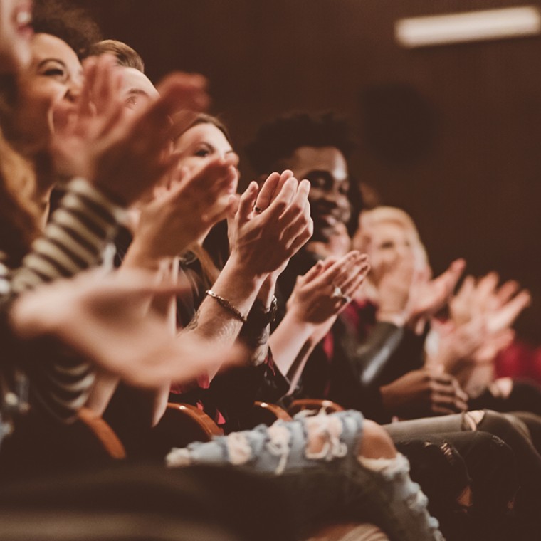 Audience clapping in theater