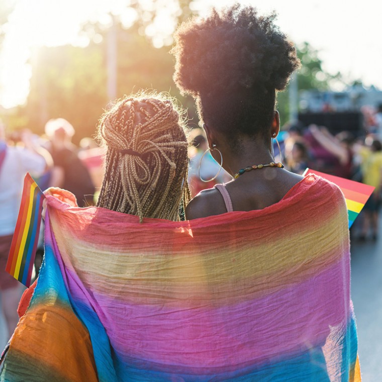 Two women holding rainbow flag