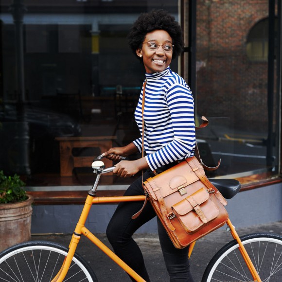 woman biking with a satchel