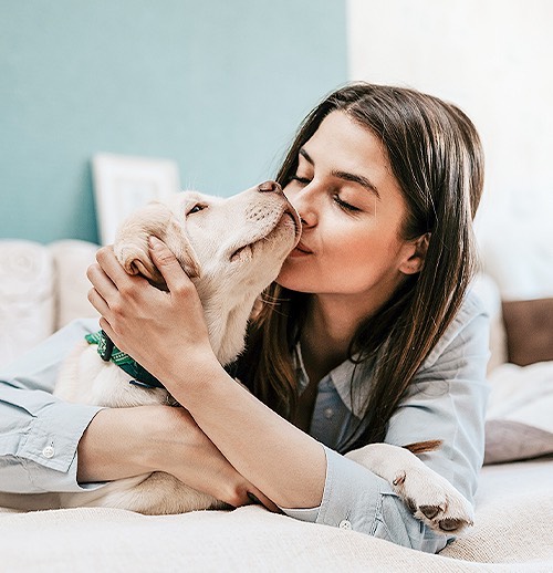 a woman kissing her dog
