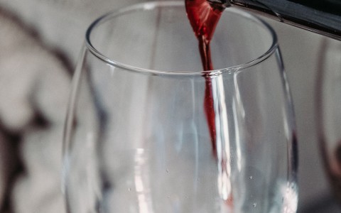 pouring of red wine in wine glass