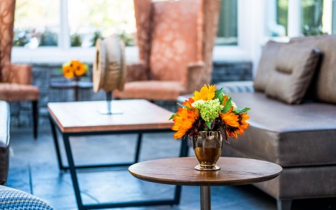 close up view of flowers in sun room with seating in the background 