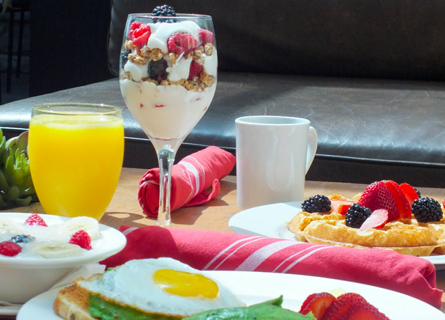 table with parfait, waffles and avocado toast