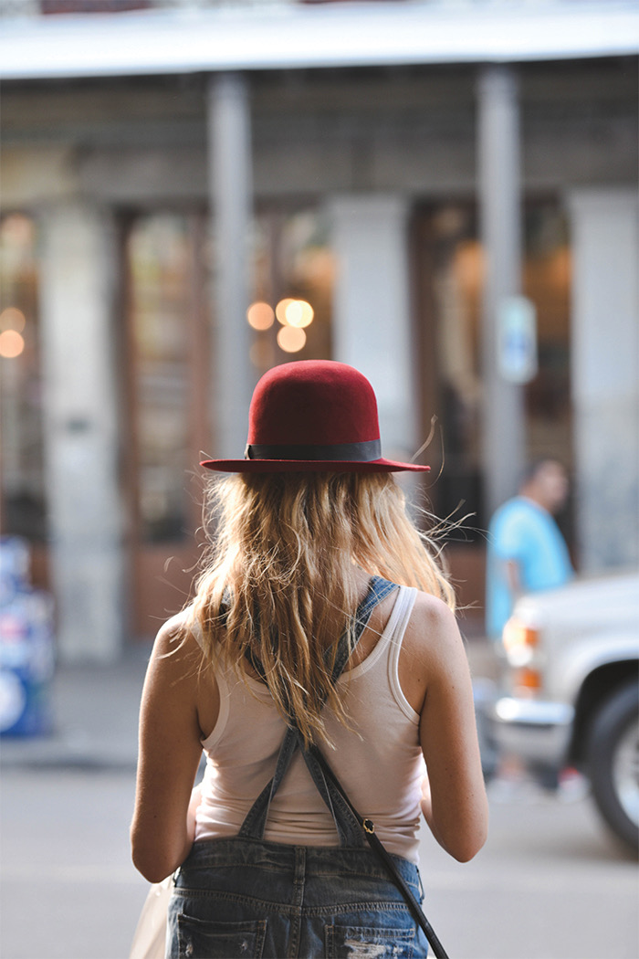 female wearing a red hat walking in New Orleans