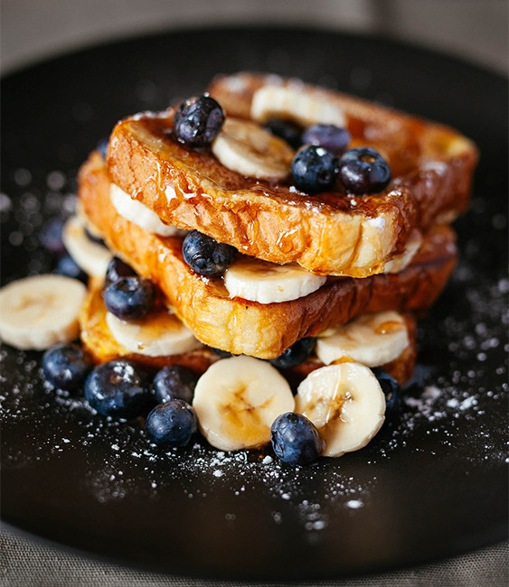 stack of french toats with bananas and blueberries