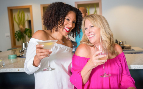 two ladies enjoying drinks and laughing together