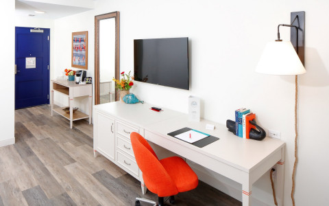 guest room with sitting desk and orange swivel chair