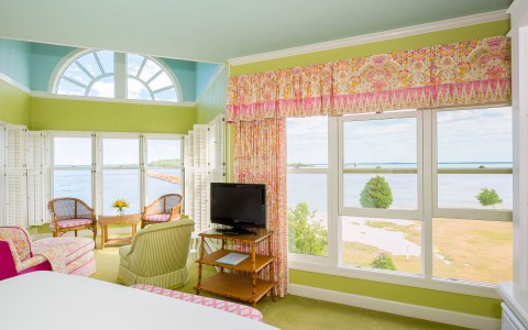 hotel room with green carpet and walls with a view of the water and a sitting area