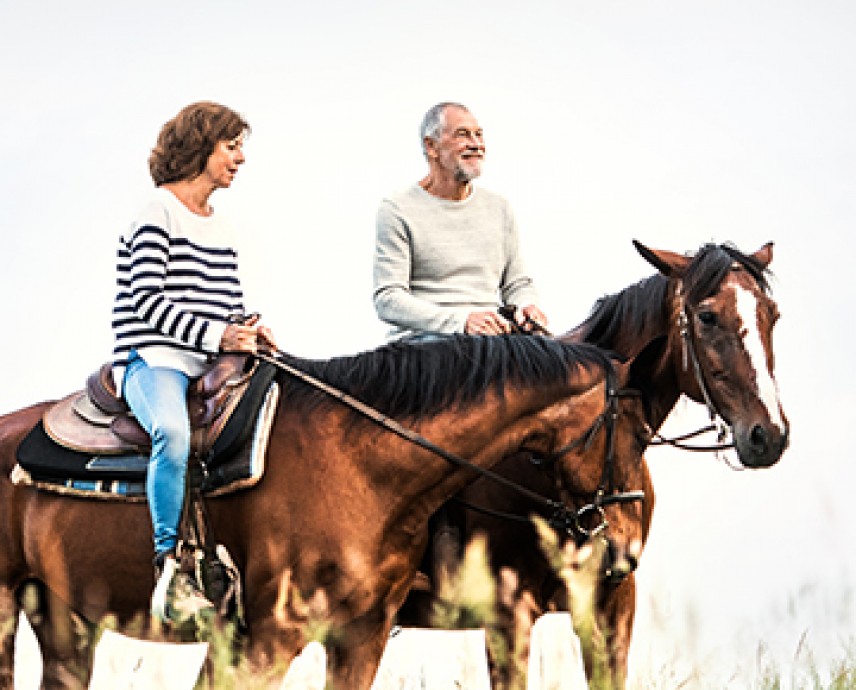 man and woman horseback riding