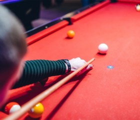 man playing on red pool table 