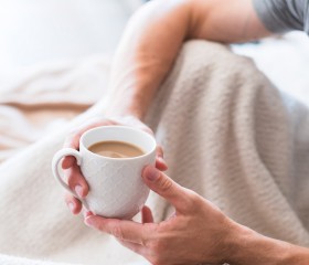man in bed with a cup of coffee 