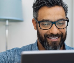 man with beard and glasses working on computer 