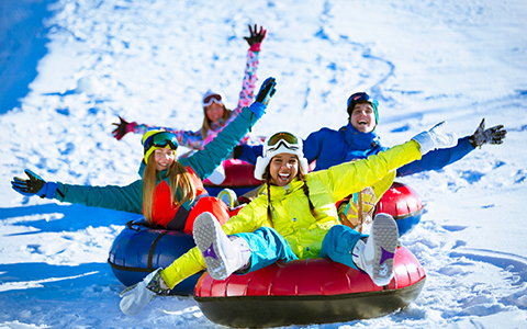 four people snow tubing
