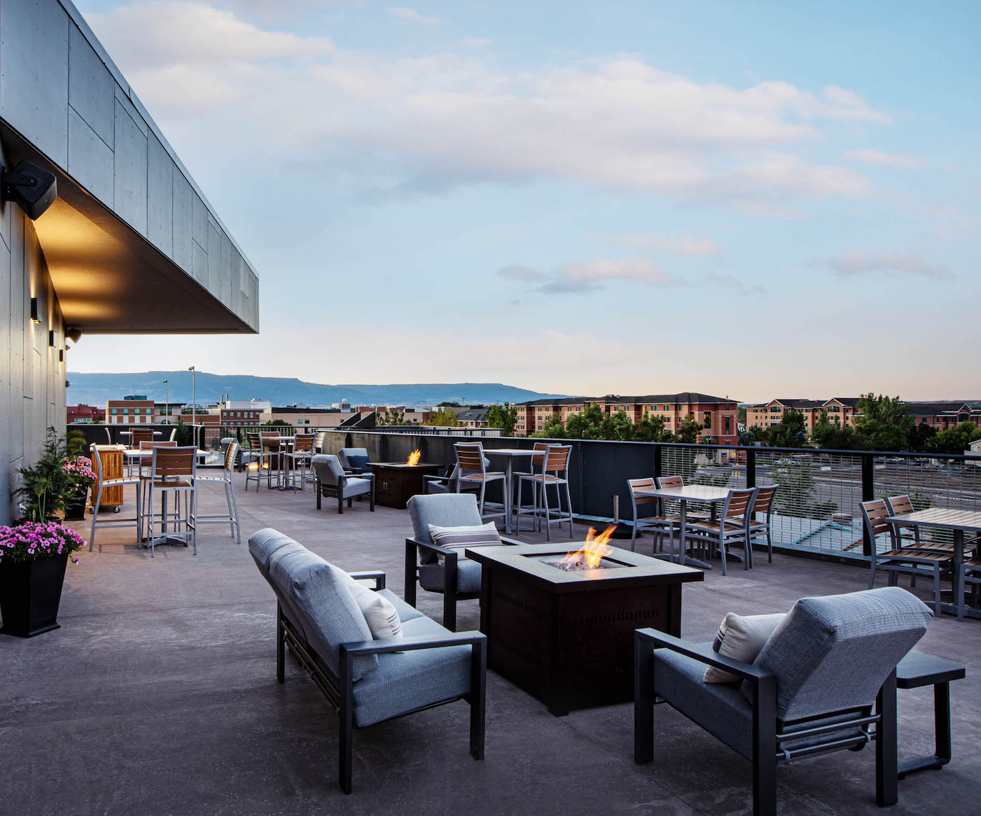 outdoor rooftop terrace with seating and a fire pit