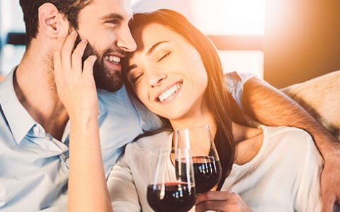 Couple smiling and drinking red wine