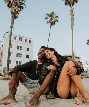 couple sitting on beach sand