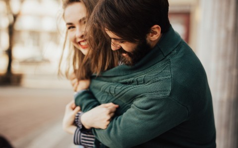 man hugging woman with his sweater 
