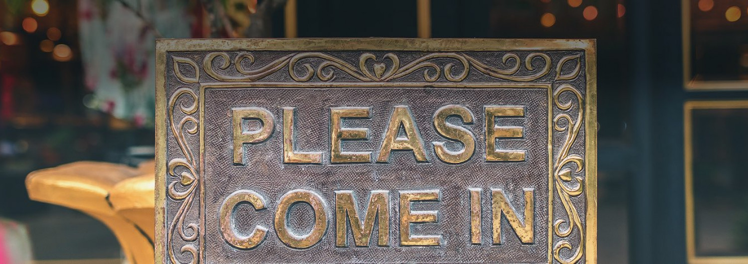 ornate plaque outside that says please come in