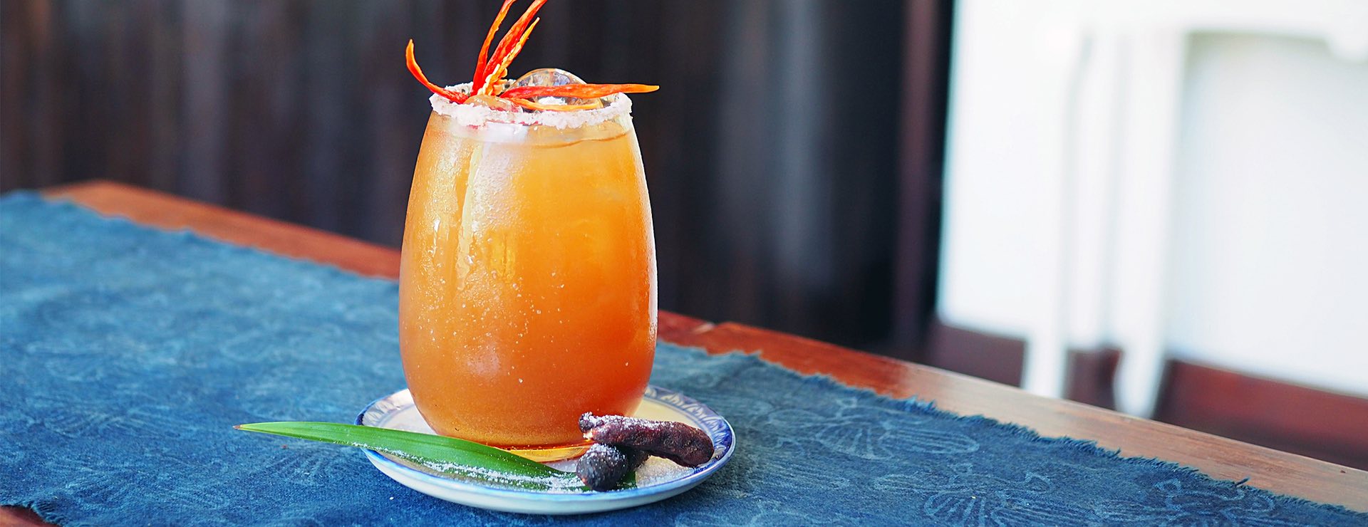 orange cocktail on blue placemat