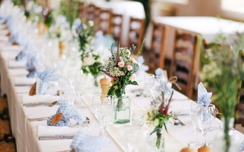 beautifully arranged table with bouquets and wine glasses with napkins 
