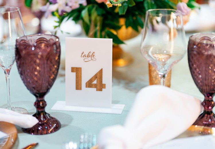 close up view to the table number fourteen with glasses around it and a napkin