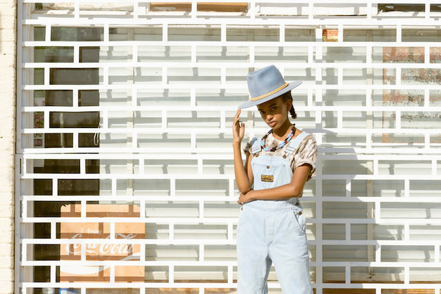 Woman posing, touching her hat