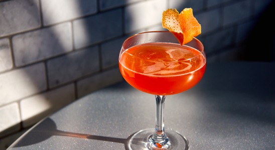 an orange cocktail glass on a table