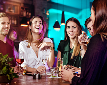 Group of people laughing and drinking at a restaurant