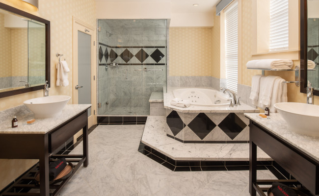 Presidential Suite bathroom with tub, shower, and two sinks