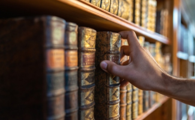 man holding book in library