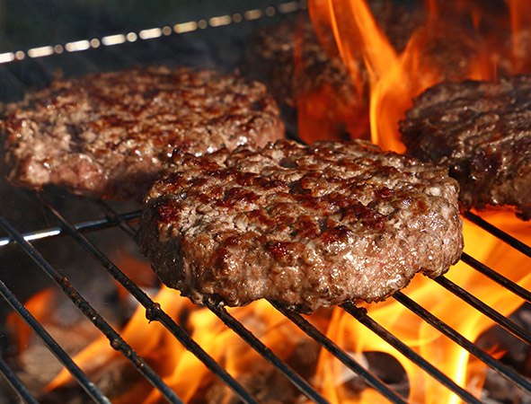 hamburgers on flaming grill