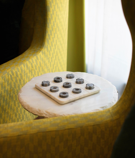 board game on side table next to two green couches