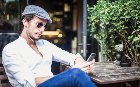 man sitting at outdoor table on cell phone
