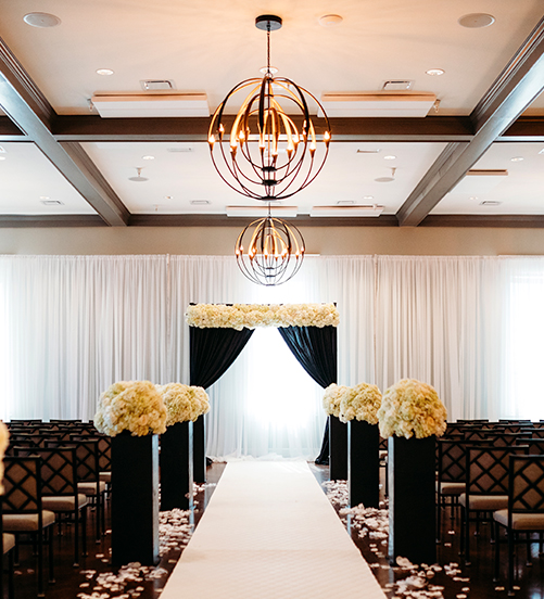 wedding ceremony with white flowers and black curtains
