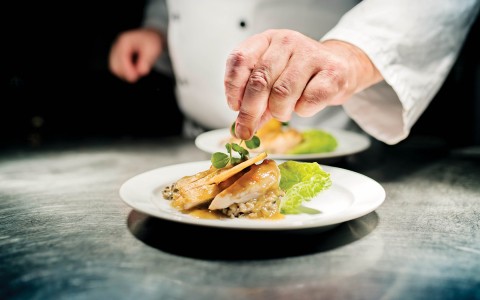 Hand of a chef finishing of a plating  dish 