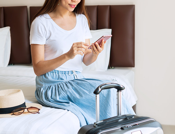 lady sitting on her bed with her luggage