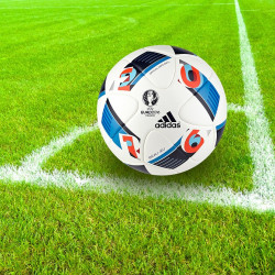 Adidas soccer ball from Euro 2016 on green grass with white chalk corner lines