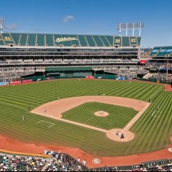 Oakland Coliseum baseball park on a sunny day. No clouds in the sky and the park is full of fans