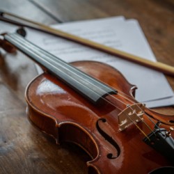 violin and music sheet on wood table