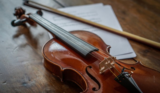 violin and music sheet on wood table