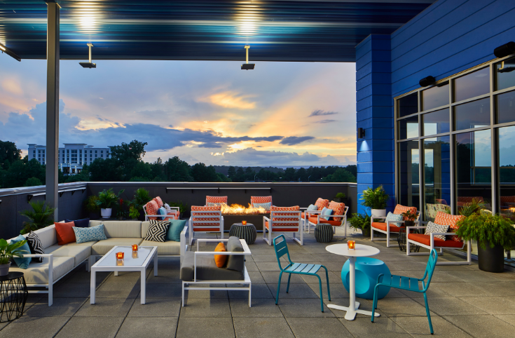 rooftop seating area with colorful chairs and a firepit