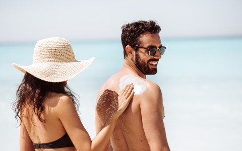 woman putting sunscreen on man